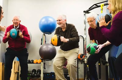 Seniors participating in a fitness class with exercise balls.