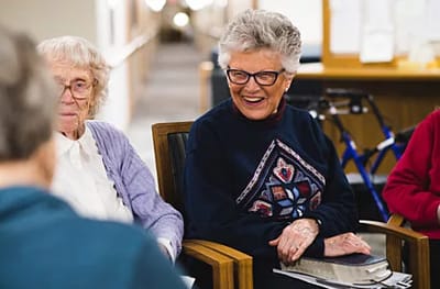Two smiling senior women engaged in conversation.