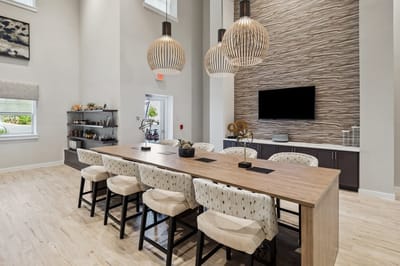 Modern common area with a long table and stylish lighting.