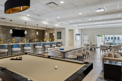 Common area with pool table and bar seating.