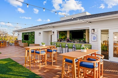 Outdoor bar area with seating and greenery.