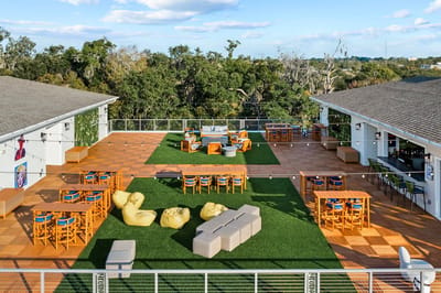 Outdoor seating area with lounge furniture and greenery.