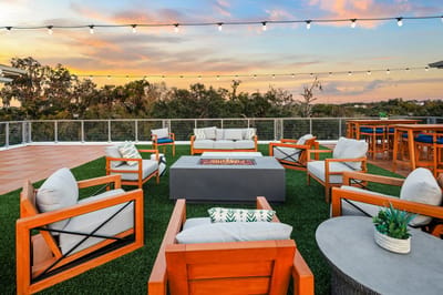 Outdoor seating area with fire pit and greenery.
