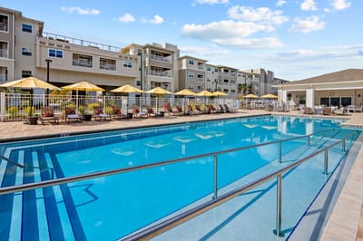 Pool area with lounge chairs and umbrellas