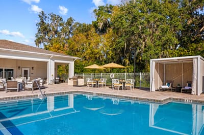 Outdoor pool area with lounge furniture and umbrellas.