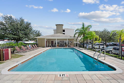 Outdoor pool area with lounge chairs and landscaping.