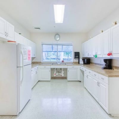 Bright kitchen area with white cabinets and appliances.
