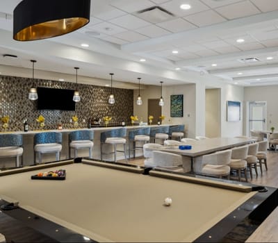 Bright common area with seating and a bar.