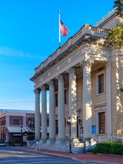 Historic building with columns and American flag.