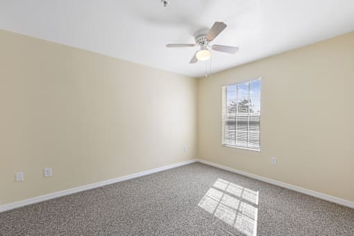 Empty room with a ceiling fan and window