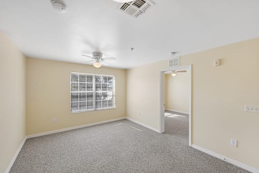 Empty resident room with a ceiling fan and window