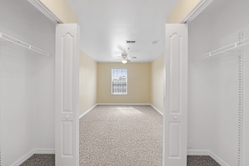 Empty resident room with beige walls and carpet.