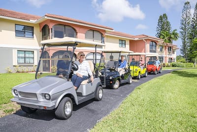 Residents enjoying a golf cart ride outside the building.