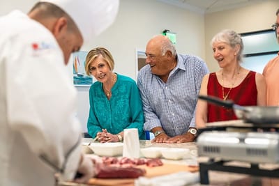 Residents enjoying a cooking activity with a chef