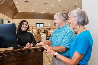 Staff assisting residents in the dining area.