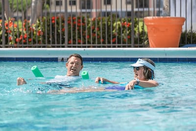 Residents enjoying a pool activity with flotation devices.