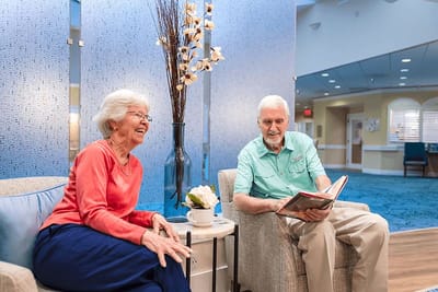Two residents in a cozy common area, smiling and engaging.
