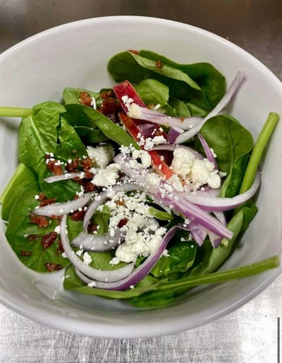 Fresh salad with spinach, onions, and cheese