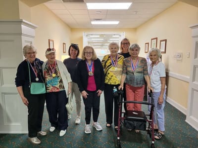 Residents celebrating with medals in a hallway