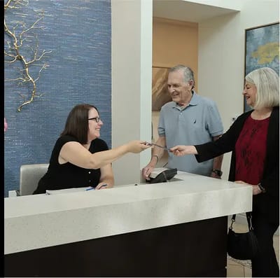Reception area with staff assisting residents.