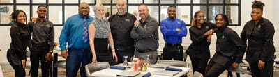 Staff members posing in a dining area.