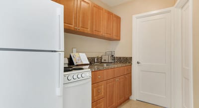 Compact kitchen with wooden cabinets and appliances