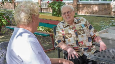 Two residents enjoying a conversation outdoors.