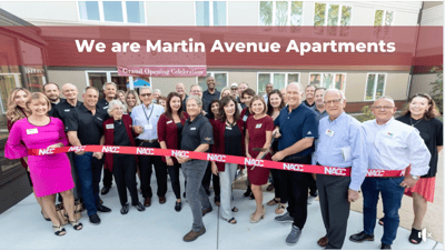 Celebration with staff and community members at ribbon-cutting event.