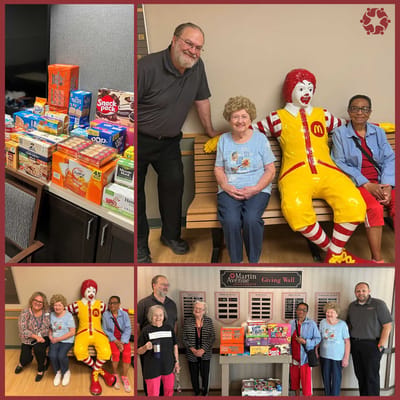 Residents enjoying a visit with a Ronald McDonald figure.
