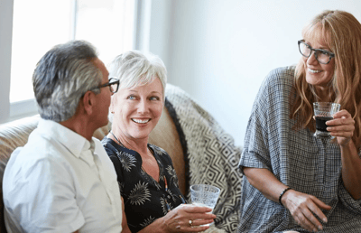 Three residents enjoying conversation on a couch.