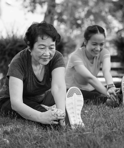 Residents participating in a stretching activity outside.