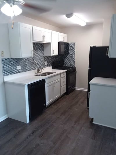 Modern kitchen with white cabinetry and appliances.