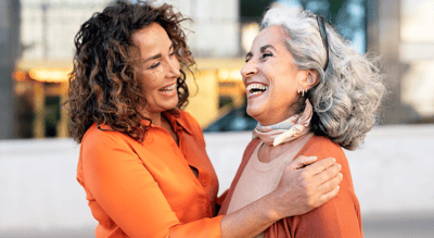 Two women enjoying a warm moment outdoors.