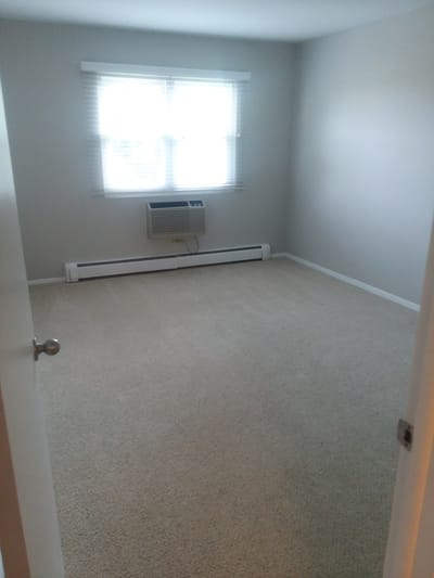 Empty room with a window and an air conditioner