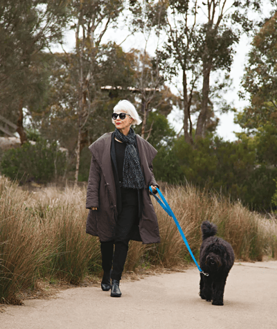 Older woman walking a dog on a path