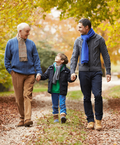 Three generations enjoying a walk in a park.