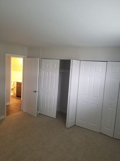 Empty bedroom with closet doors open