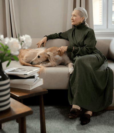 Senior woman relaxing with a dog in a cozy room.