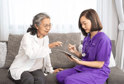 Healthcare professional and senior resident interacting with a tablet