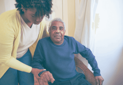 A caregiver assisting a senior man in a comfortable setting
