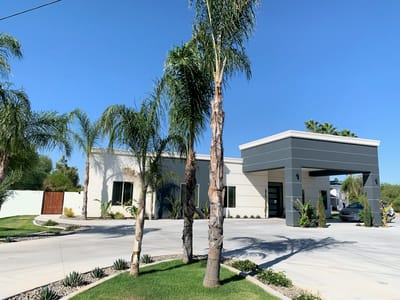 Exterior view of Agave Manor entrance with palm trees