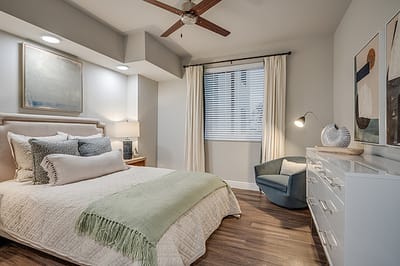 Brightly decorated resident room with a bed and artwork