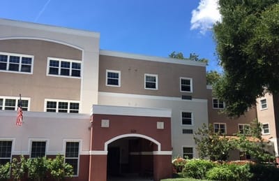 Exterior view of Apostles Village building with blue sky