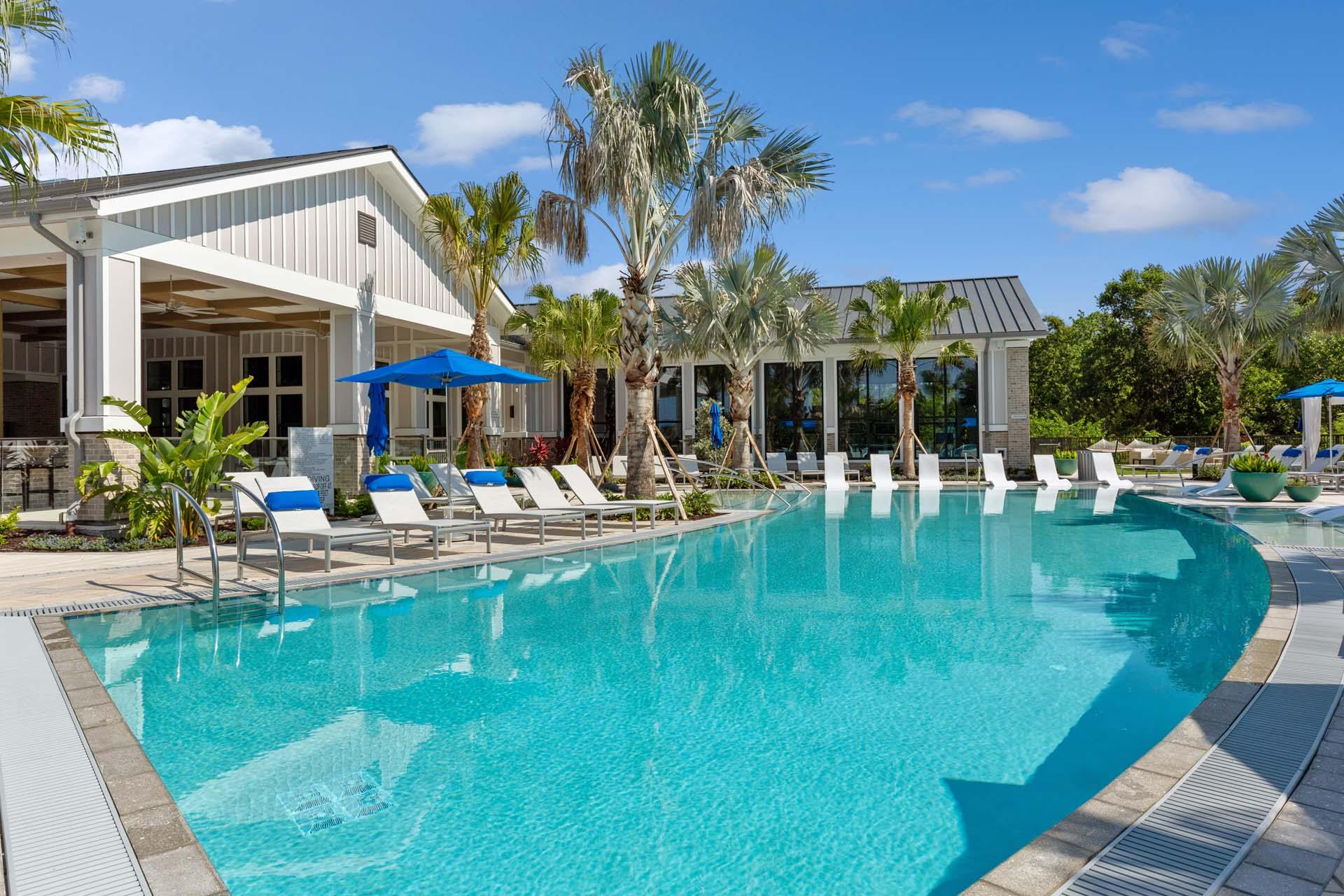 A pool area surrounded by palm trees and seating