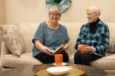 Two residents enjoying conversation on a couch