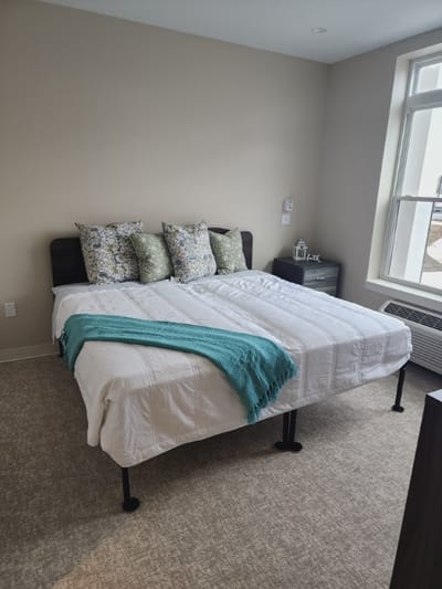 Cozy private bedroom with bed and decorative pillows