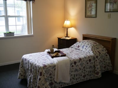 Cozy resident room with a bed, lamp, and decor