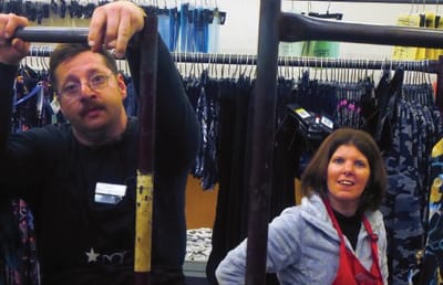 Two staff members working on a clothing rack.