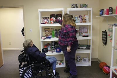 Resident and staff member interact in common area.