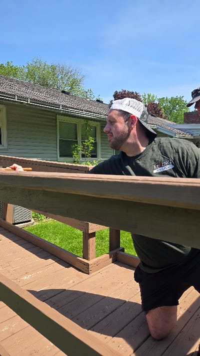 Man painting a wooden deck in an outdoor space